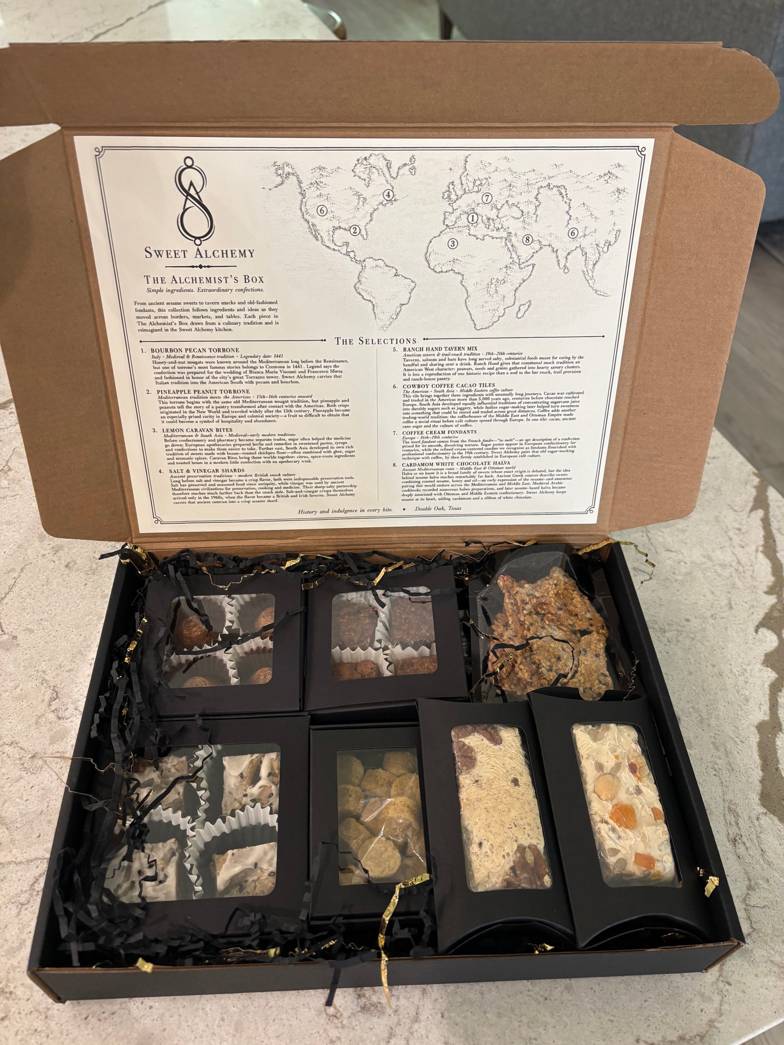 Opened custom gift box featuring a printed map, curation notes and confection stories