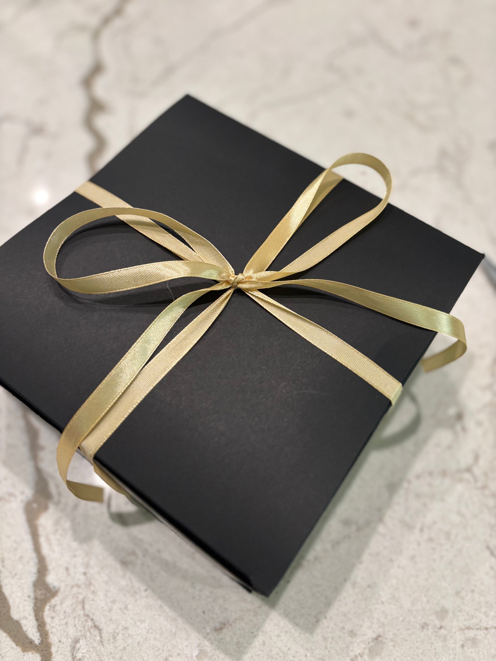Black gift box with gold ribbon for the holiday season
